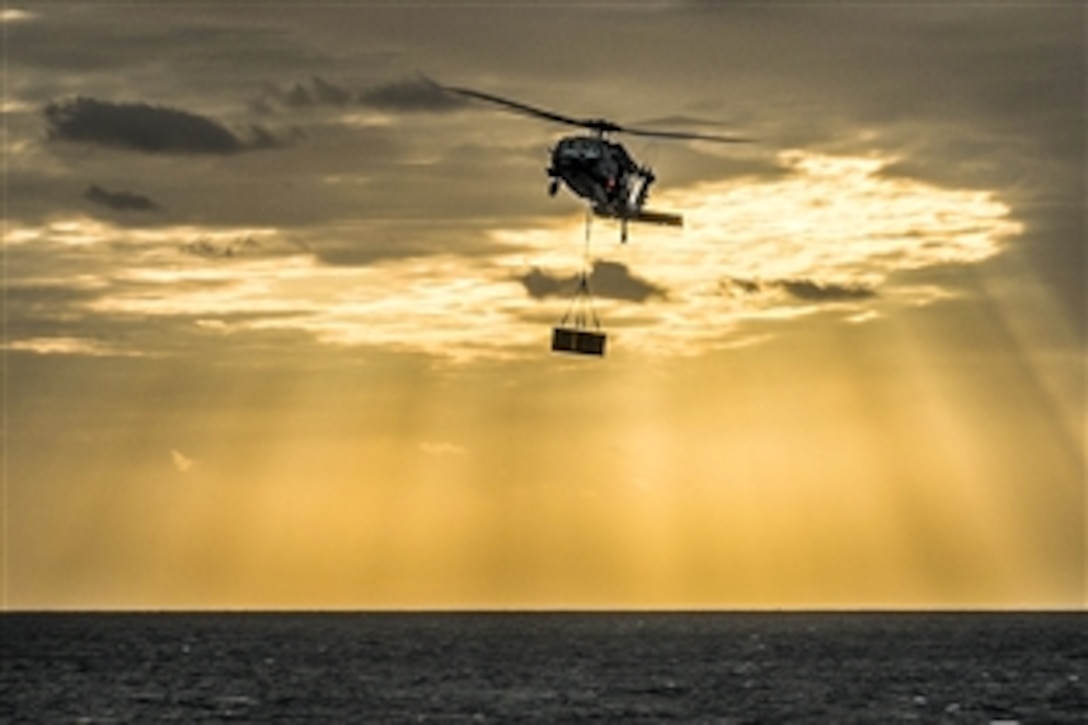 An MH-60S Seahawk helicopter delivers supplies to the amphibious assault ship USS Bonhomme Richard during a replenishment in the East China Sea, March 24, 2015. The helicopter is assigned to Helicopter Sea Combat Squadron 25.