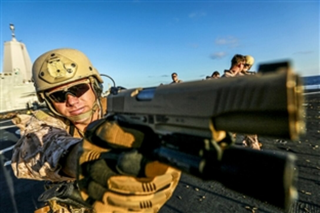 Marine Gunnery Sgt. Mickey Eaton sights in with his M1911 .45-caliber pistol at a target during training on the USS Anchorage off the coast of San Diego, March 23, 2015. Eaton is an assistant operations chief assigned to the 15th Marine Expeditionary Unit's Maritime Raid Force. 
