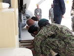 Lt. Col. Michael Masiker, in background, watches at Afghan National Army members work on a project. Masiker, a member of the Ohio Air National Guard's 180th Fighter Wing, is currently assigned here as the logistics director for the 438th Air Expeditionary Wing.