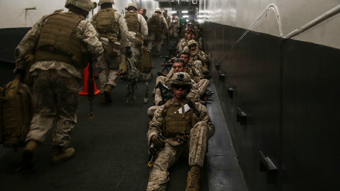 U.S. Marines with Lima Company, Battalion Landing Team 3rd Battalion, 1st Marine Regiment, 15th Marine Expeditionary Unit, wait to depart the USS Essex (LHD 2) on a simulated airfield seizure mission during Composite Training Unit Exercise (COMPTUEX) March 22, 2015. These Marines inserted onto San Clemente Island where they practiced clearing and securing combat towns in preparation for the MEU’s upcoming deployment. (U.S. Marine Corps photo by Cpl. Anna Albrecht/Released)