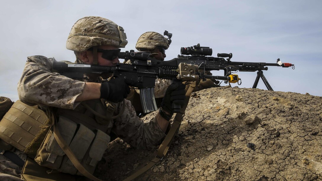 U.S. Marines with Lima Company, Battalion Landing Team 3rd Battalion, 1st Marine Regiment, 15th Marine Expeditionary Unit, provide over-watch on their objective during an airfield seizure mission as part of Composite Training Unit Exercise (COMPTUEX) on San Clemente Island, Calif., March 22, 2015. These Marines inserted onto the island from the USS Essex (LHD 2) to execute a raid and practice their urban combat skills. (U.S. Marine Corps photo by Cpl. Anna Albrecht/Released)