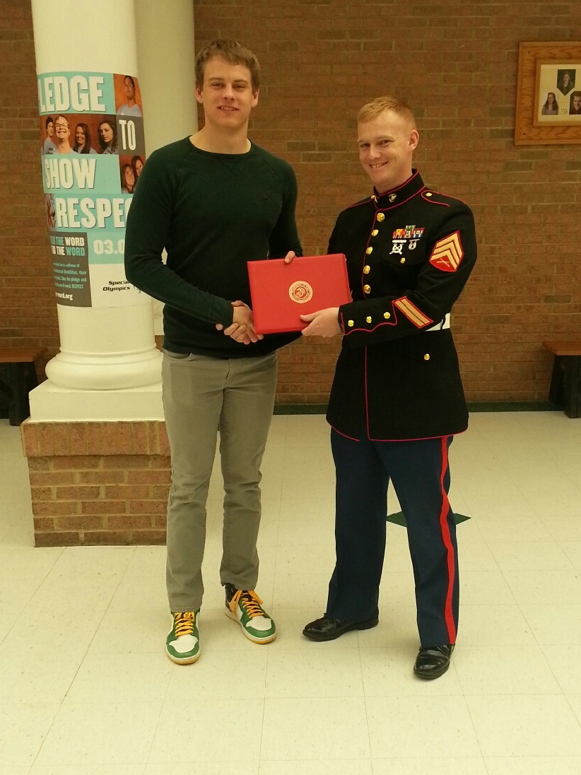 Joe Burrow, the Athens High School quarterback in Athens, Ohio, received a certificate of participation from U.S. Marine Corps Sgt. David A. Wood, a Recruiting Station Charleston recruiter, and native of San Bernardino, California, for playing in the Marine Corps Semper Fidelis Bowl, Jan 4, 2015, at Carson, California. The certificate was presented to Burrow, March 24 in front of the student body in the school cafeteria. (Courtesy photo provided by Sgt. David A. Wood/Released)