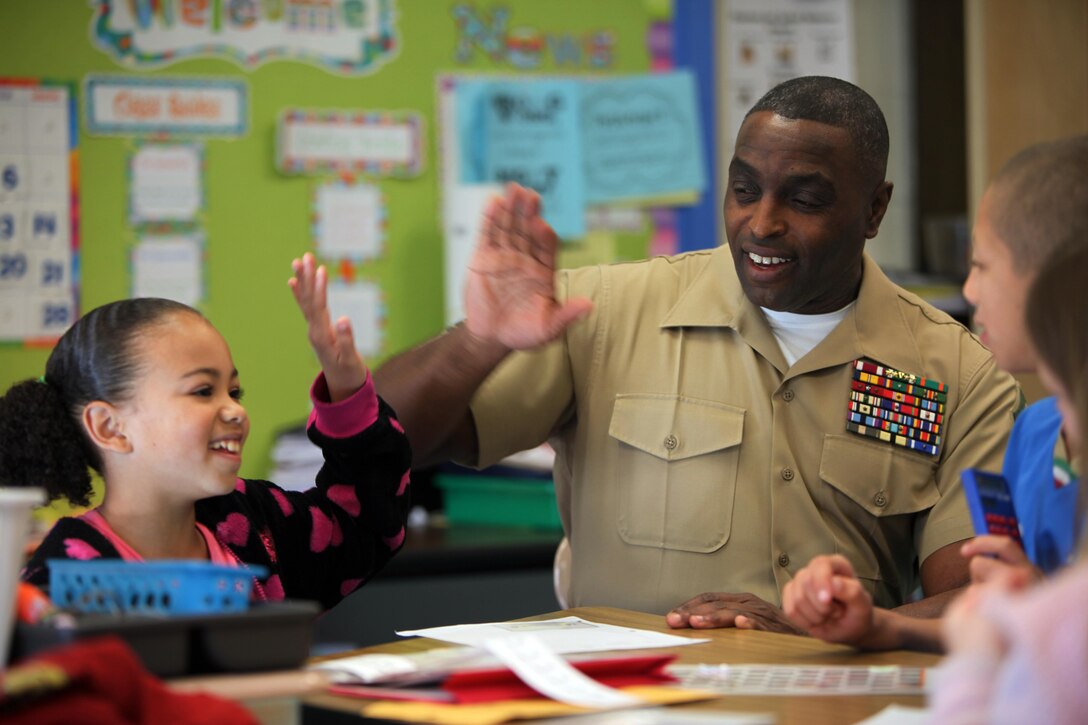 Sgt. Maj. Darrell D. Rowe high fives Shyanna B., 8, after completing a math problem, at Arthur W. Edwards Elementary School in Havelock, N.C., March 13, 2015. Marines and Sailors with Marine Wing Support Squadron 274 volunteered at the elementary school to interact with the students on an academic level and to show them a different side of the Marine Corps. The Marines helped the students with reading, writing and math skills. Rowe is the sergeant major of MWSS-274 and Shyanna is a 3rd grade student with the school.