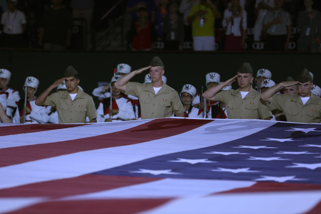 Marines from the Marine Corps Communications-Electronic School salute the American Flag during the playing of national anthem at the Banque Nationale de Paris Paribas Tennis Open’s Salute to Heroes Ceremony in Indian Wells, Calif., March 13, 2015. The Combat Center Color Guard and more than 80 Marines Participated in the ceremony. (Official Marine Corps Photo by Lance Cpl. Julio McGraw/Released)
