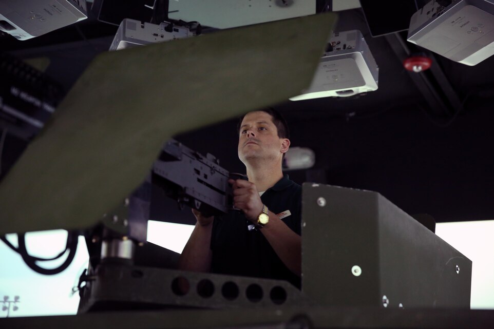 Chris Bennett, marketing manager, City of Palm Desert, operates a simulated .50-caliber machine gun at the Combat Convoy Simulator during a tour of the Combat Center March 5, 2015. The CCS allowed the representatives to experience how Marines respond to one another while in a simulated environment. (Official Marine Corps photo by Lance Cpl. Thomas Mudd/ Released)