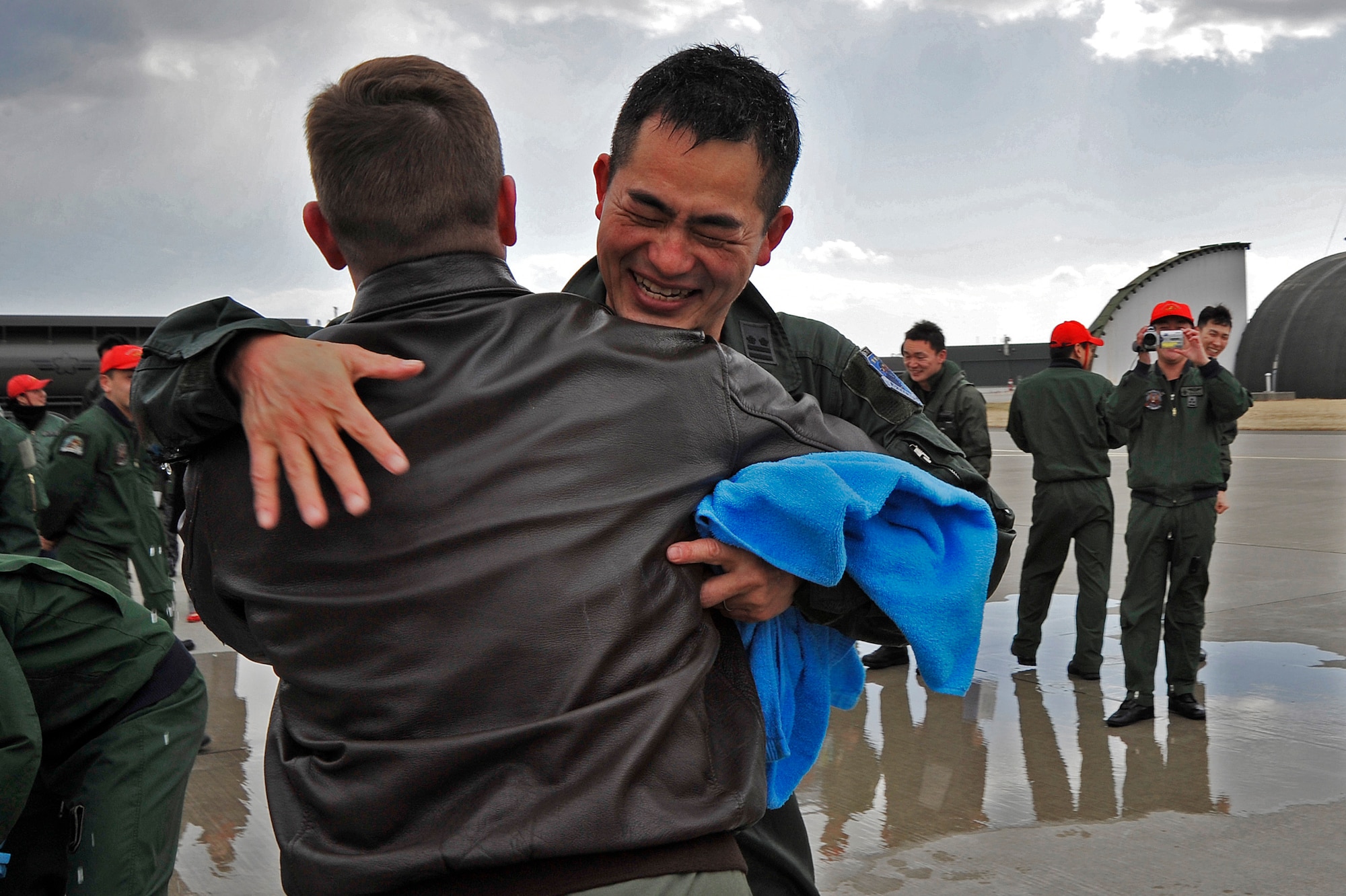 U.S. Air Force Maj. Ryan Serrill, 35th Fighter Wing director of staff, embraces Japan Air Self-Defense Force Lt. Col. Katsushi "Kitty" Hashimoto, 3rd Tactical Fighter Squadron commander, during a fini-flight celebration at Misawa Air Base, Japan, March 23, 2015. More than seven years ago, Hashimoto was selected as an exchange officer assigned to the 61st Fighter Squadron at Luke Air Force Base, Arizona, where he had the opportunity to work side by side with Serrill. (U.S. Air Force photo by Senior Airman Jose L. Hernandez-Domitilo/Released)