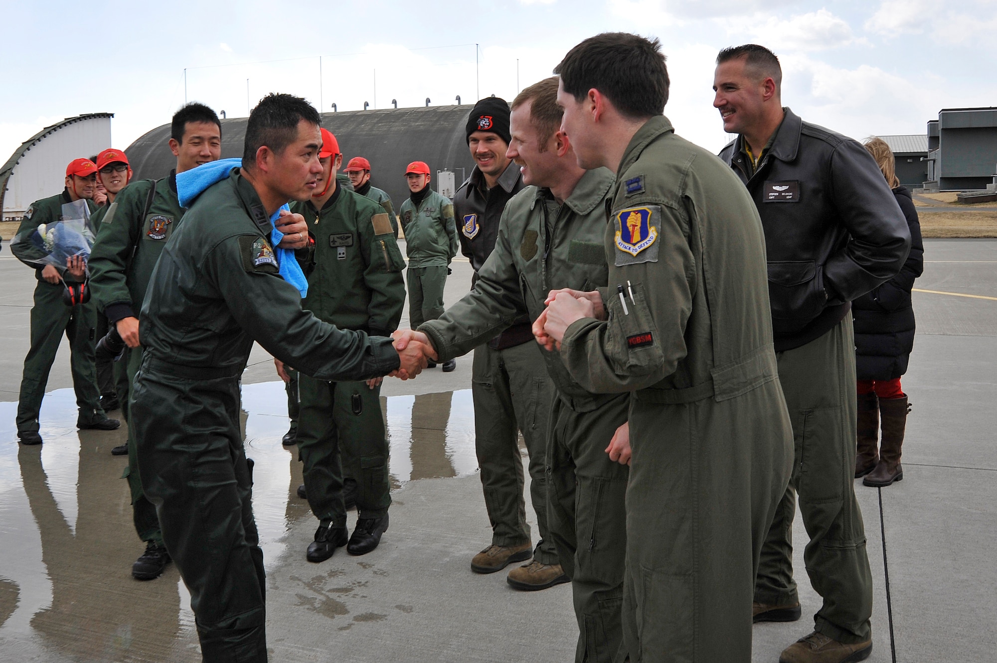 Japan Air Self-Defense Force Lt. Col. Katsushi "Kitty" Hashimoto, 3rd Tactical Fighter Squadron commander, thanks U.S. Air Force Capt. Jonathan Kay, 13th Fighter Squadron pilot, for taking part in his fini-flight at Misawa Air Base, Japan, March 23, 2015. 13th FS pilots and friends of Hashimoto from the 35th Fighter Wing showed JASDF members a different style of fini-flight common among U.S. fighter pilots. U.S. service members at Misawa AB maintain one of the strongest relationships with the local community and its military counterparts. (U.S. Air Force photo by Senior Airman Jose L. Hernandez-Domitilo/Released)
