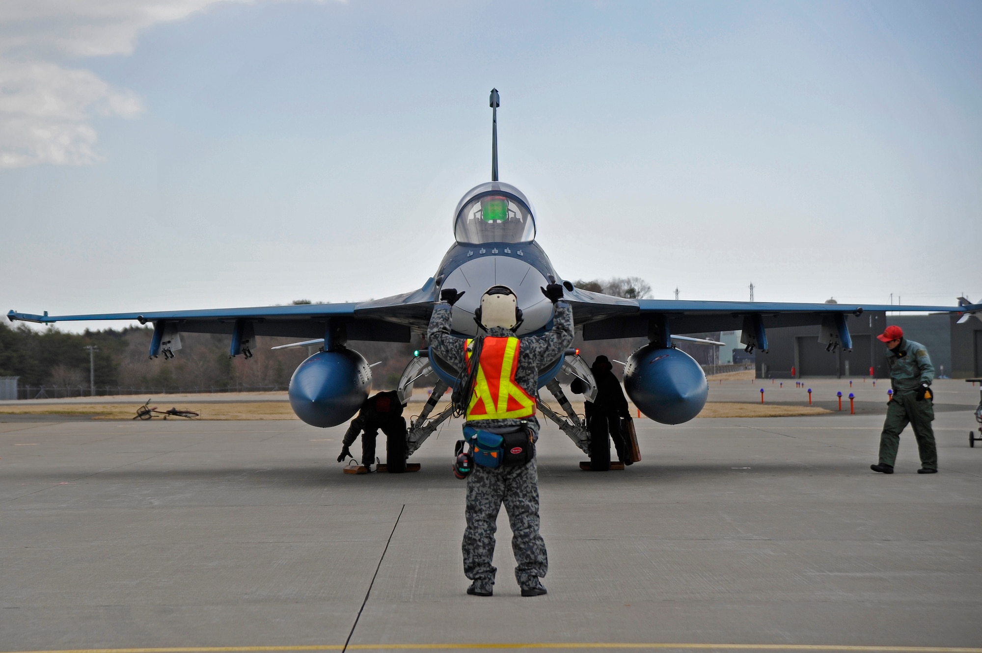 A Japan Air Self-Defense Force maintainer directs a JASDF F-2 piloted by Lt. Col. Katsushi "Kitty" Hashimoto, 3rd Tactical Fighter Squadron commander, at Misawa Air Base, Japan, March 23, 2015. Hashimoto was piloting his last flight in the JASDF F-2 at Misawa AB, where he has been stationed for the past four years and worked closely with U.S. pilots. For more than 50 years the Japanese have shared the runway at Misawa AB, conducting flight operations to maintain readiness and provide security in the Pacific. (U.S. Air Force photo by Senior Airman Jose L. Hernandez-Domitilo/Released)