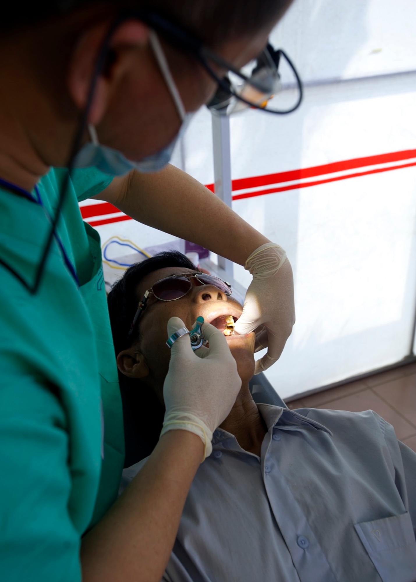 U.S. Navy Lt. Hai Doan, 1st Dental Battalion general dentist, Camp Pendleton, Calif., gives anesthesia to a patient prior to an extraction during a Operation Pacific Angel 15-3 health service outreach event at Dung Quat Culture - Sports Center, Quang Ngai Province, Vietnam March 23, 2015. The annual regional humanitarian assistance and disaster relief operation provided general health, dental, optometry, pediatrics, and engineering programs to the local people, which helped to foster host nation and multilateral partnership. (U.S. Air Force photo by Staff Sgt. Tong Duong/ Released)