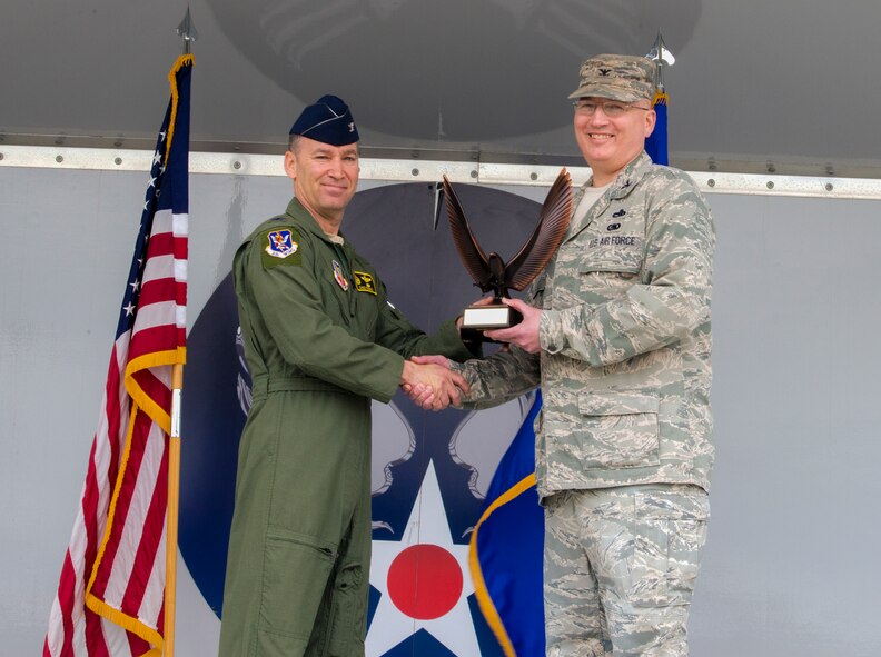 U.S. Air Force Col. Jeffrey Decker, 23d Maintenance Group commander, right, receives the Clements McMullen Memorial Daedalian Weapon System Maintenance Trophy from Col. Chad Franks, 23d Wing commander, March 23, 2015, at Moody Air Force Base, Ga. The 23d MXG provided serviceable and available equipment for deploying aircrew members which generated 13,450 sorties and over 34,790 flying hours. (U.S. Air Force photo by Airman Greg Nash/Released)