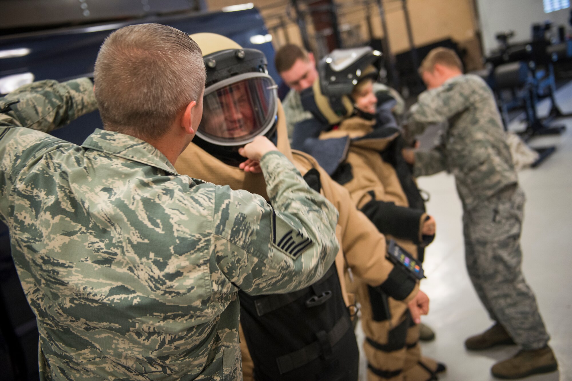 U.S. Air Force Master Sgt. Stanley Thompson, 23d Civil Engineer Squadron Explosives Ordnance Disposal, fastens an EOD 9 bomb suit helmet on Chad Slaughter, member of the Leadership Lowndes Class of 2015, March 19, 2015 at Moody Air Force Base, Ga, The bomb suit protects EOD members when they have to manually diffuse a bomb. (U.S. Air Force photo by Andrea Jenkins/Released)



