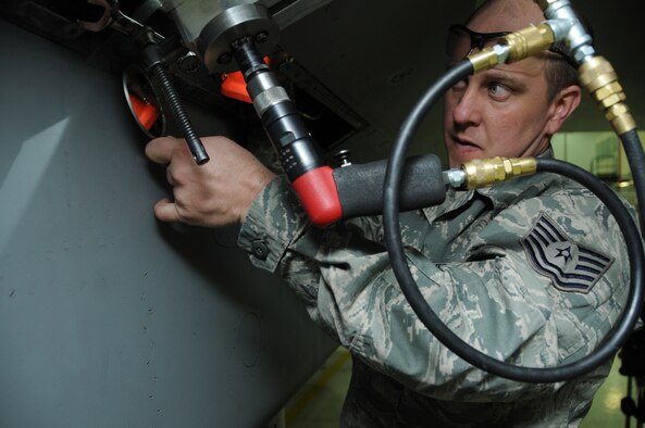 Tech. Sgt. Jeff Childs, 173rd Fighter Wing sheet metals shop, requires a small mirror to help ensure his cutting tool does not cut the wing spar while taking fine cuts measuring only a thousandths of-an-inch on the skin of an F-15 aircraft wing. While removing the quarter inch of titanium skin covering the wing, the delicate part is ensuring he does not
damage the underlying spar. (U.S. Air National Guard photo by Tech. Sgt. Jefferson Thompson/released)

