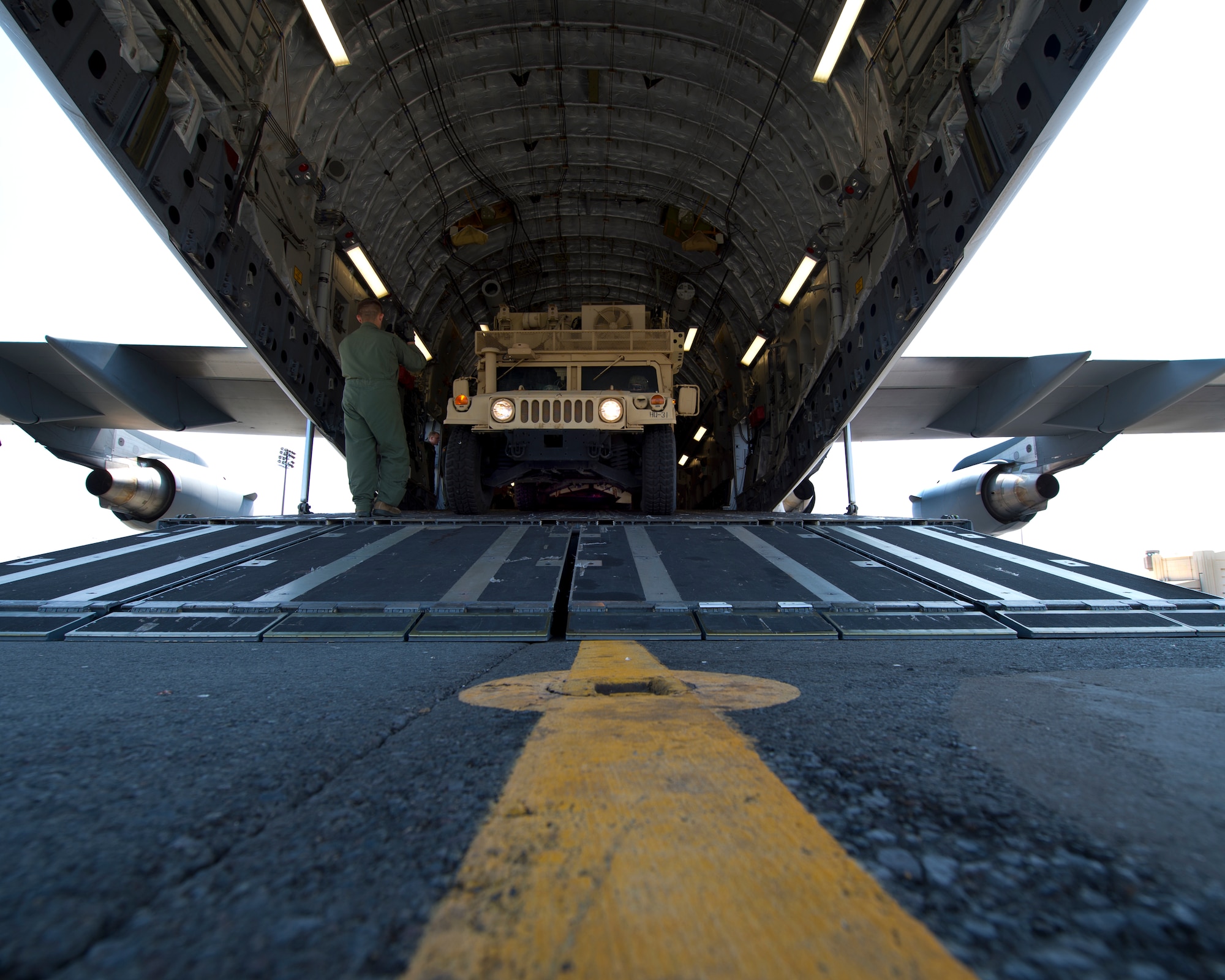 Staff Sgt. Dylan Porras, a loadmaster from the 535th Airlift Squadron, directs the driver of a tactical base of operation vehicle from the 2nd Brigade, 25th Infantry Division into a C-17 Globemaster III as part of joint training between the Army and Air Force on Joint Base Pearl Harbor-Hickam, Hawaii, March 18, 2015. The six loadmasters from the 535th AS and six Army infantrymen from 2nd BG were trained on how to load three tactical base of operations vehicles with trailers into the C-17. (U.S. Air Force photo by Tech. Sgt. Aaron Oelrich/Released)          