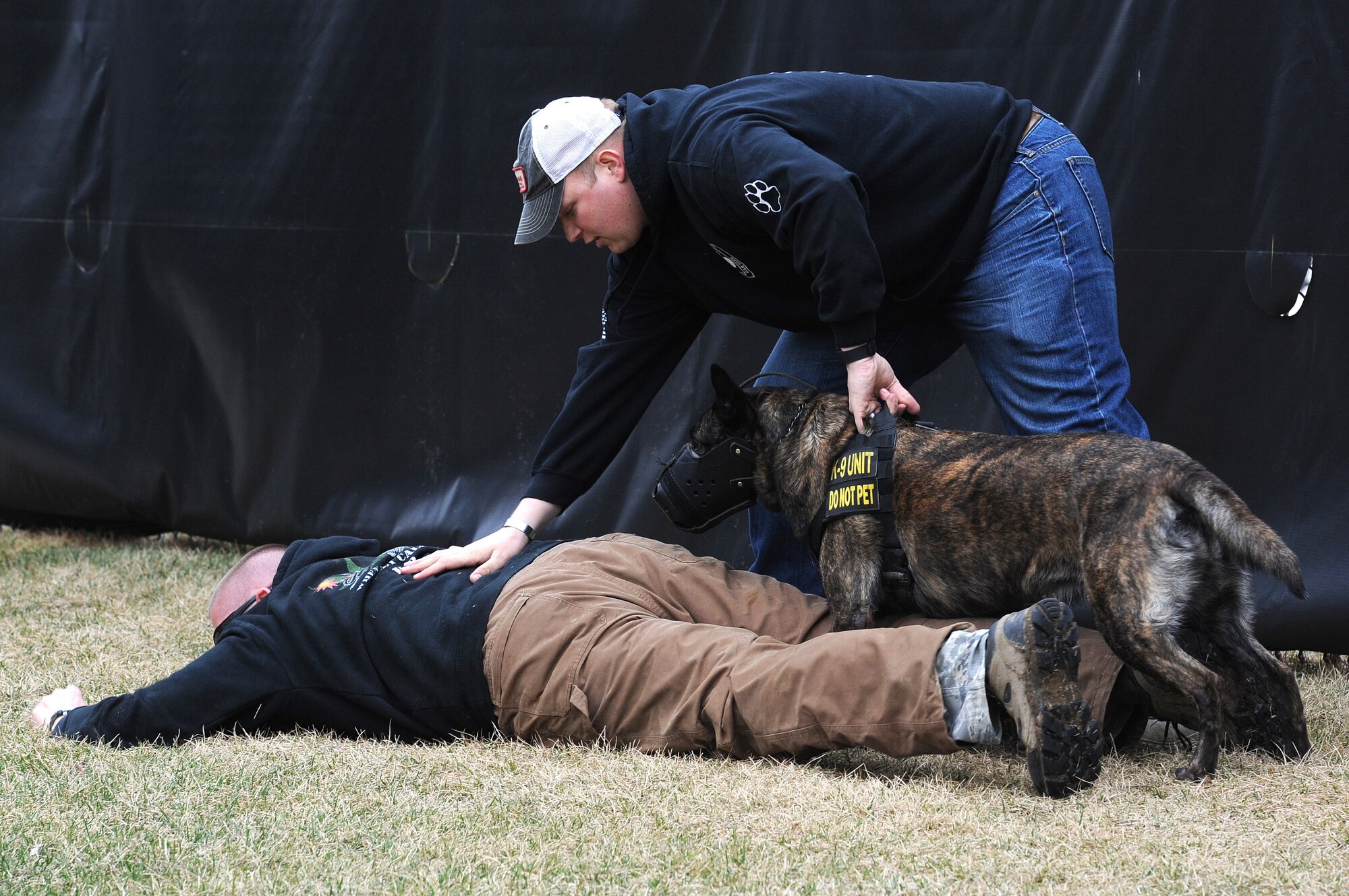 Staff. Sgt. David Yaronczyk, 375th Security Forces Squadron military working dog handler, pats down  Tech. Sgt. Bryan Dell, 375th SFS NCOIC military working dog section, as Fay, 375th SFS military working dog, watches during muzzle aggression training March 20, 2015, at the 375th SFS Military Working Dog Kennels at Scott Air Force Base, Ill. After a MWD gets to their base they are matched up with a handler based on availability but are also attempted to be matched up based on personality so the handler and dog mesh. (U.S. Air Force photo/ Senior Airman Tristin English)