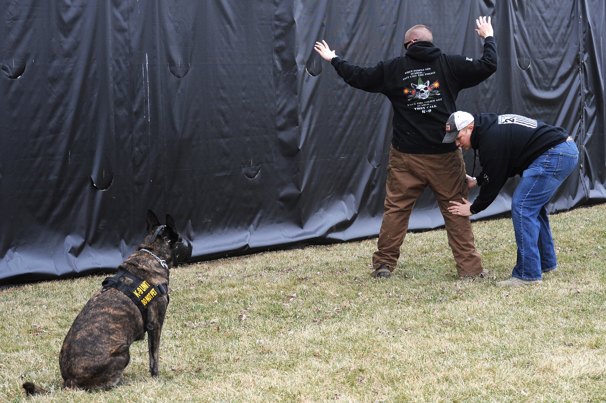 Staff. Sgt. David Yaronczyk, 375th Security Forces Squadron military working dog handler, pats down  Tech. Sgt. Bryan Dell, 375th SFS NCOIC military working dog section, as Fay, 375th SFS military working dog, watches during muzzle aggression training March 20, 2015, at the 375th SFS Military Working Dog Kennels at Scott Air Force Base, Ill. After a MWD gets to their base they are matched up with a handler based on availability but are also attempted to be matched up based on personality so the handler and dog mesh. (U.S. Air Force photo/ Senior Airman Tristin English)