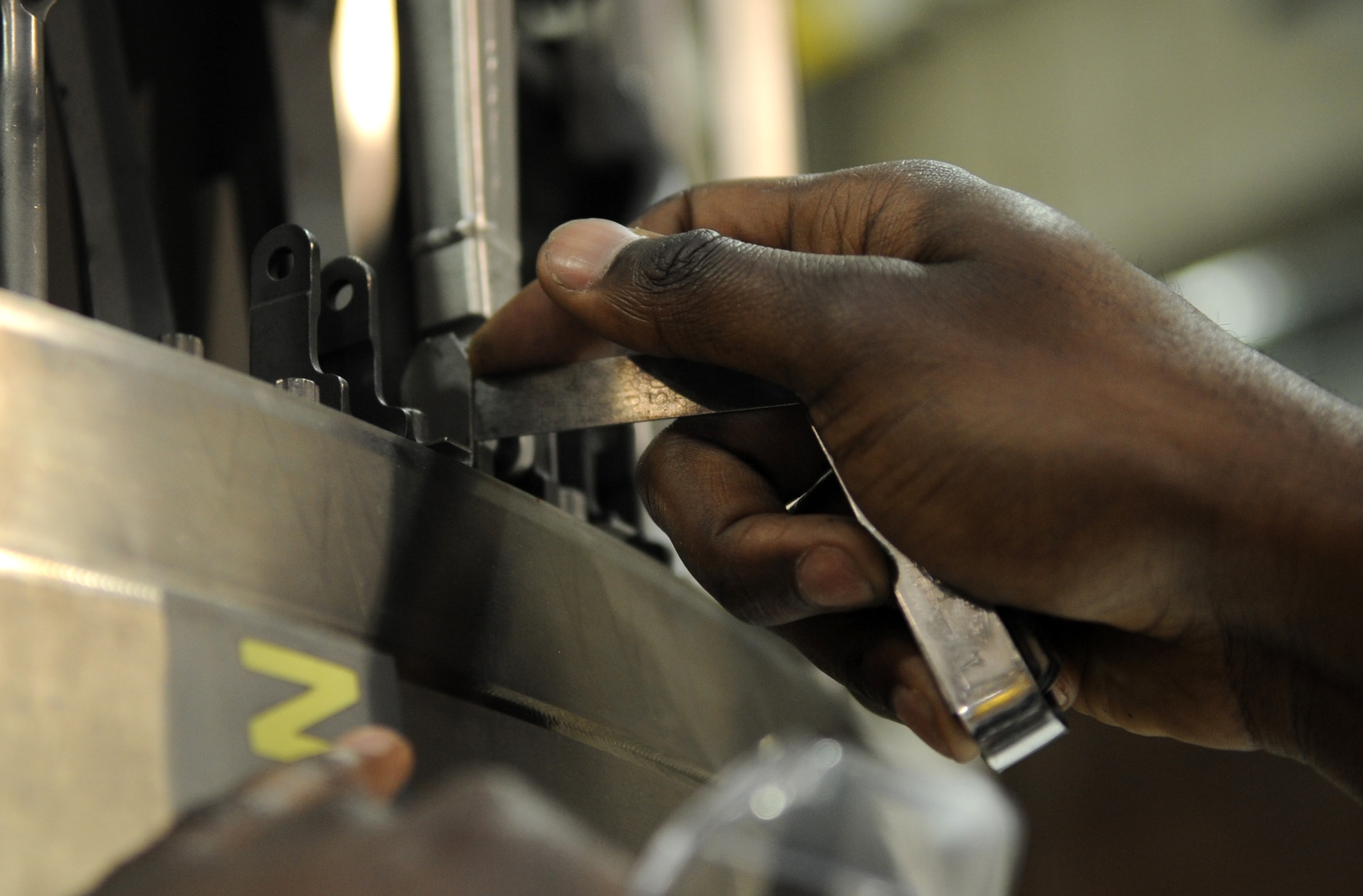 Airman 1st Class  Mitchell Dixon, 4th Component Maintenance Squadron aerospace propulsion journeyman, tightens bolts on an F-15E Strike Eagle engine augmenter module, March 9, 2015, at Seymour Johnson Air Force Base, North Carolina. Dixon raps, sings, and plays several instruments, which led him to audition for Tops in Blue in early 2015. (U.S. Air Force photo/Senior Airman Ashley J. Thum) 