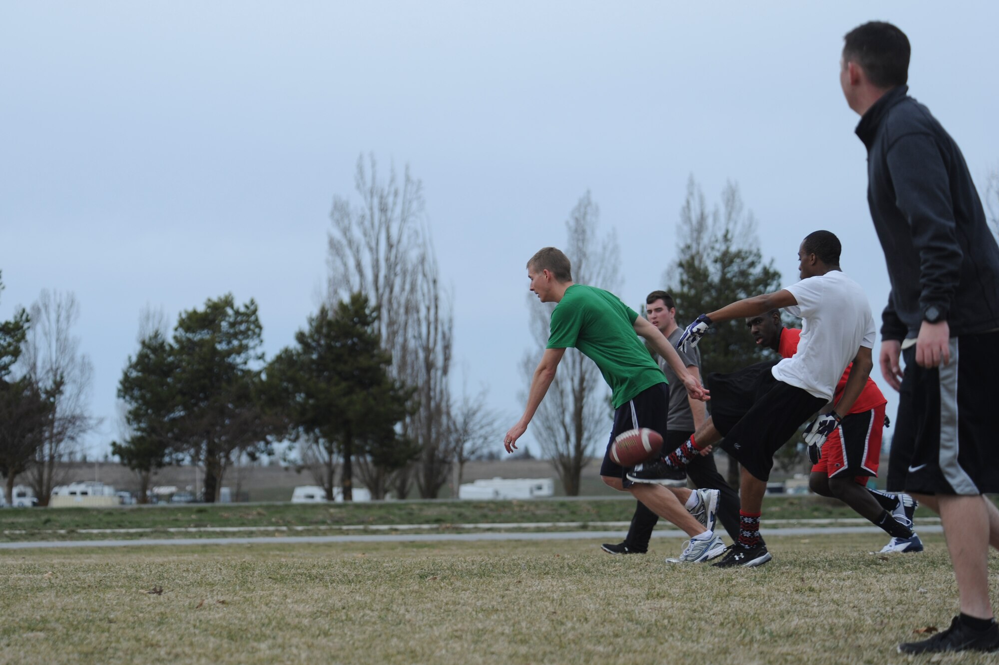 Members of Team Fairchild punt a football to the opposing team during Winter Sports Day, March 20, 2015, on the football field at Fairchild Air Force Base, Wash. Members ran, passed and sweated during the ultimate football games. (U.S. Air Force photo/Airman 1st Class Nicolo J. Daniello)