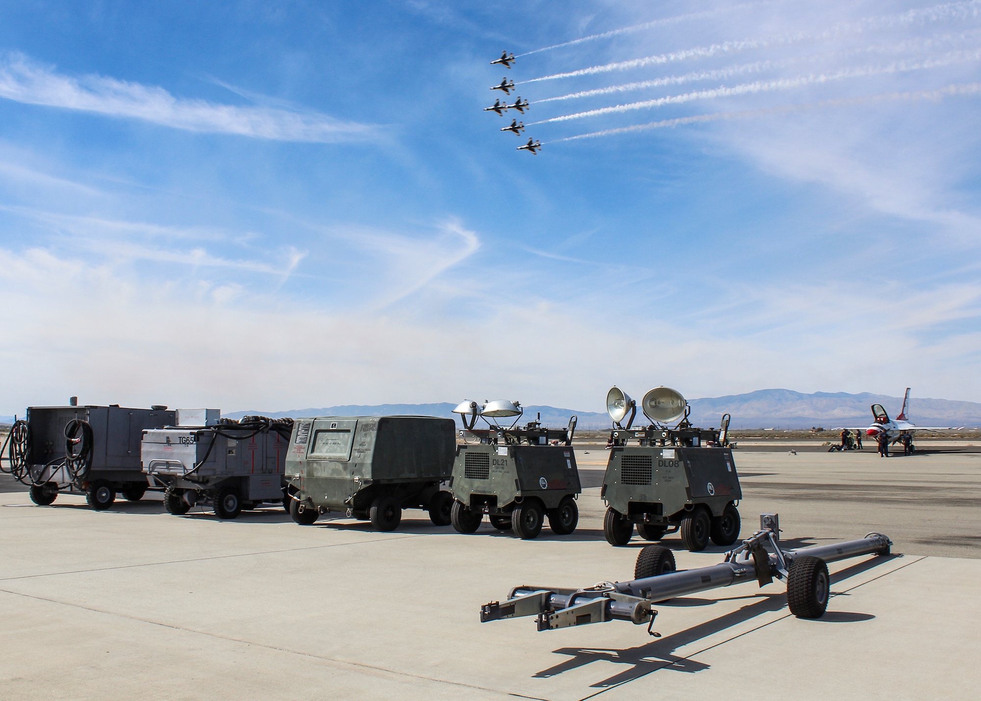 Aerospace Ground Equipment on loan from the 412th Maintenance Squadron sit on the flightline as the U.S. Air Force Thunderbirds soar over head during the L.A. County Air Show. (U.S. Air Force photo by Melissa Buchanan)