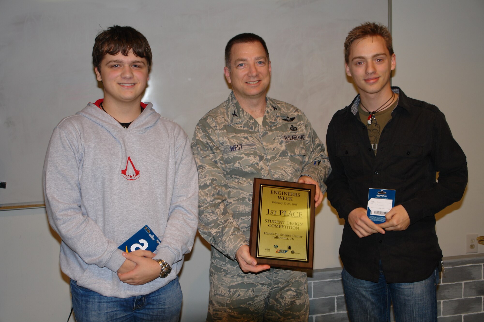 First place winners of the Engineers Week Student Design Competition, Jacob Parnham and Sam West with Coffee County Central High School, accept their award Feb. 24 at the Hands on Science Center from Col. Timothy West, director of the AEDC Test Operations Division. (Photos provided)