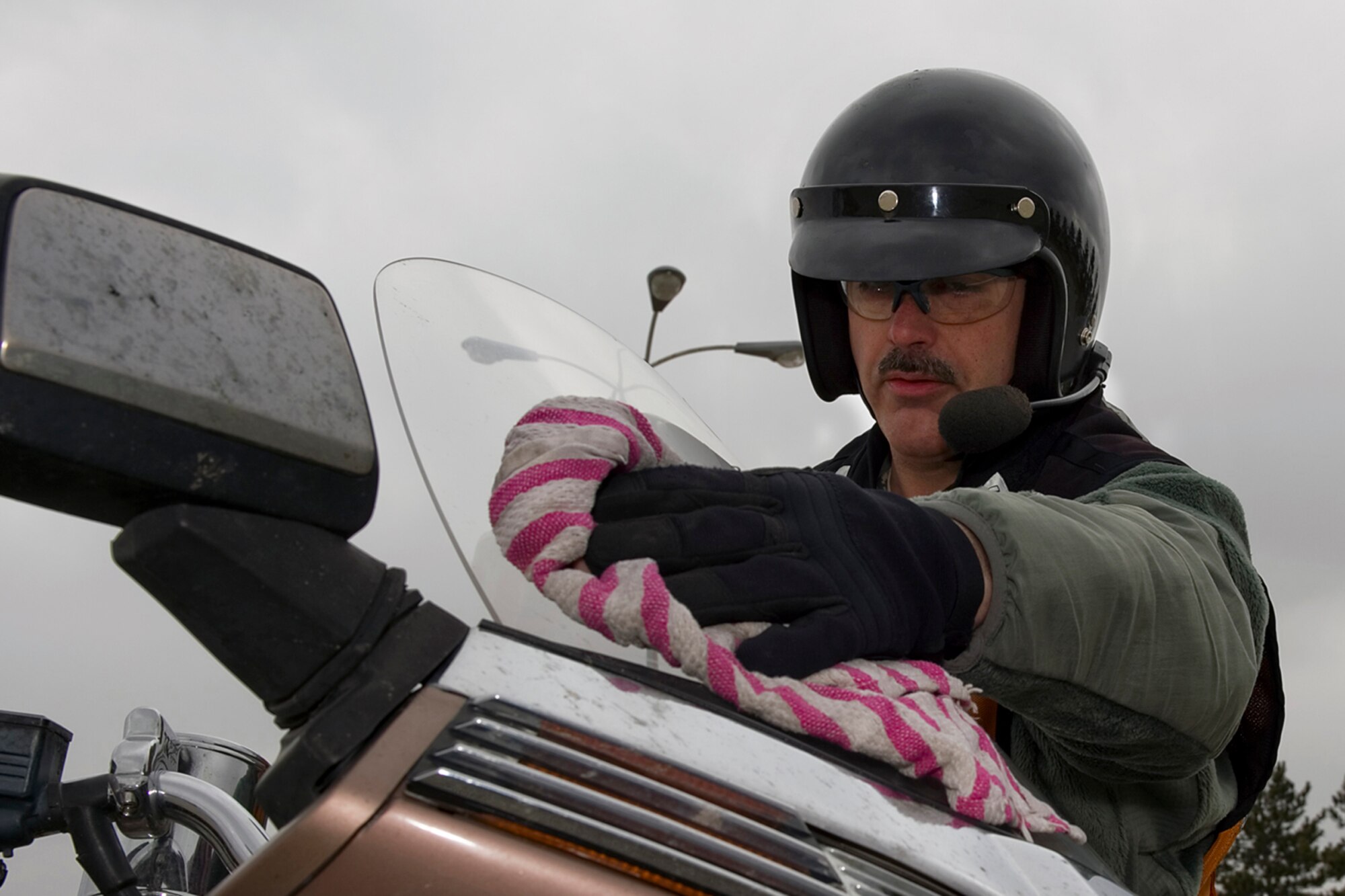Tech. Sgt. John Thompson, 434th Aircraft Maintenance Squadron crew chief, cleans his motorcycle windshield while demonstrating a pre-ride inspection at Grissom Air Reserve Base, Ind., March 20, 2015. Thompson uses the inspection and a variety of other risk management tools to ensure he's safe when riding his motorcycle. (U.S. Air Force photo/Tech. Sgt. Benjamin Mota) 
