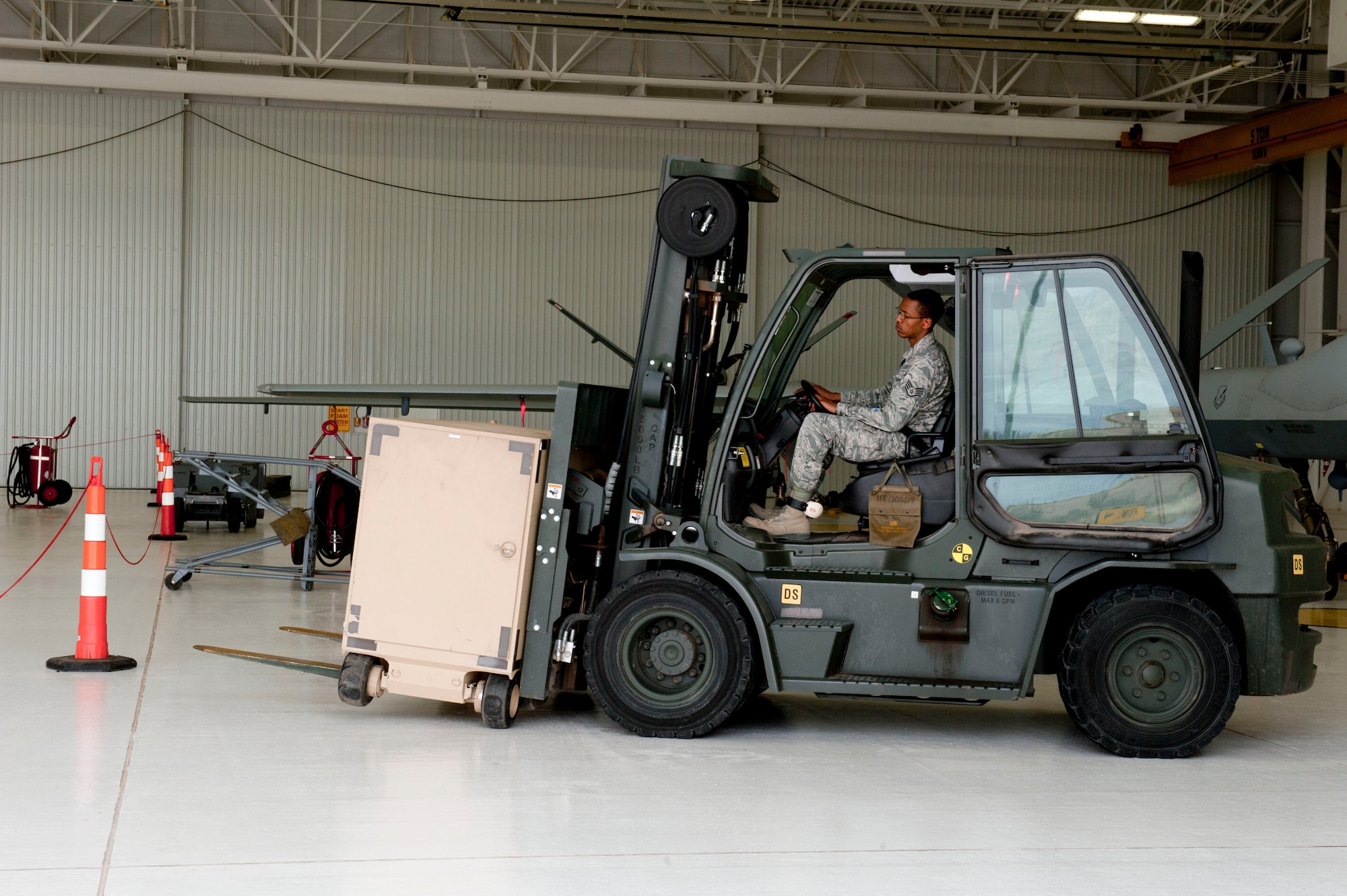 Staff Sgt. Justin Wray, 49th Aircraft Maintenance Squadron Avionic specialist craftsman, uses a forklift to deliver a Ruggedized Aircraft Maintenance Test Station (RAMTS) to a hangar at Holloman Air Force Base, N.M. March 18, 2015. The RAMTS are used to perform operational checks on the aircraft after any maintenance is completed. (U.S. Air Force photo by Staff Sgt. E’Lysia A. Wray/Released)