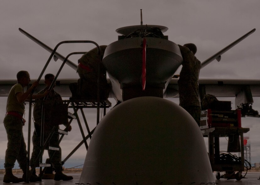 Members from the 49th Aircraft Maintenance Squadron Avionics flight, work as a cohesive unit during regular scheduled maintenance on the MQ-9 Reaper at Holloman Air Force Base, N.M. March 18, 2015. “Reliable teamwork and constant communication, ensures our team is effective and sustains quality maintenance,” said Staff Sgt. Justin Wray, a 49th Aircraft Maintenance Squadron Avionic specialist craftsman. (U.S. Air Force photo by Staff Sgt. E’Lysia A. Wray/Released)