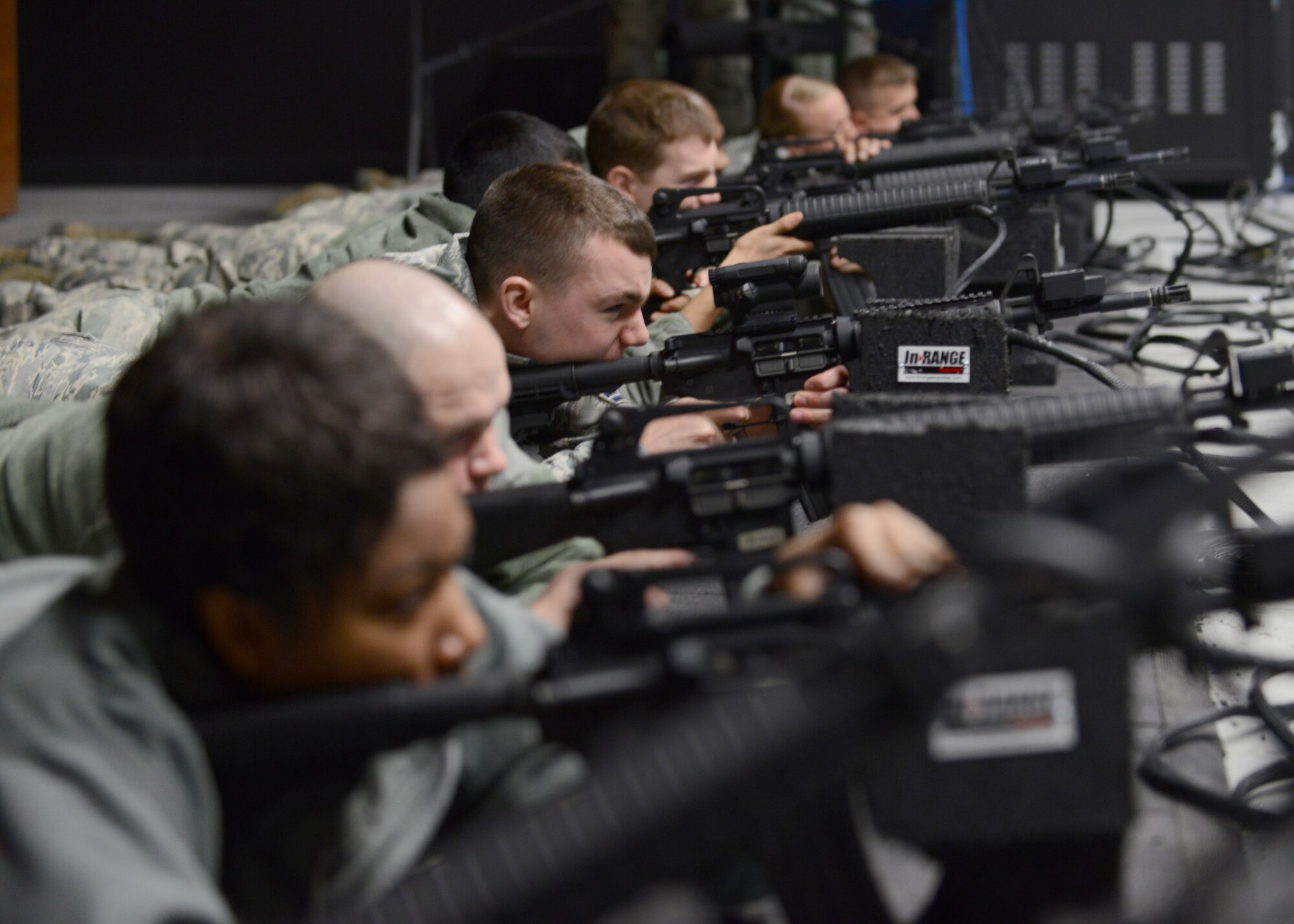 U.S. Airmen shoot simulated targets on an engagement skills trainer at the Combat Arms Training and Maintenance facility Feb. 12, 2015, Eielson Air Force Base, Alaska. Airmen attended an M4 requalification course.  (U.S. Air Force photo by Senior Airman Ashley Taylor/Released)