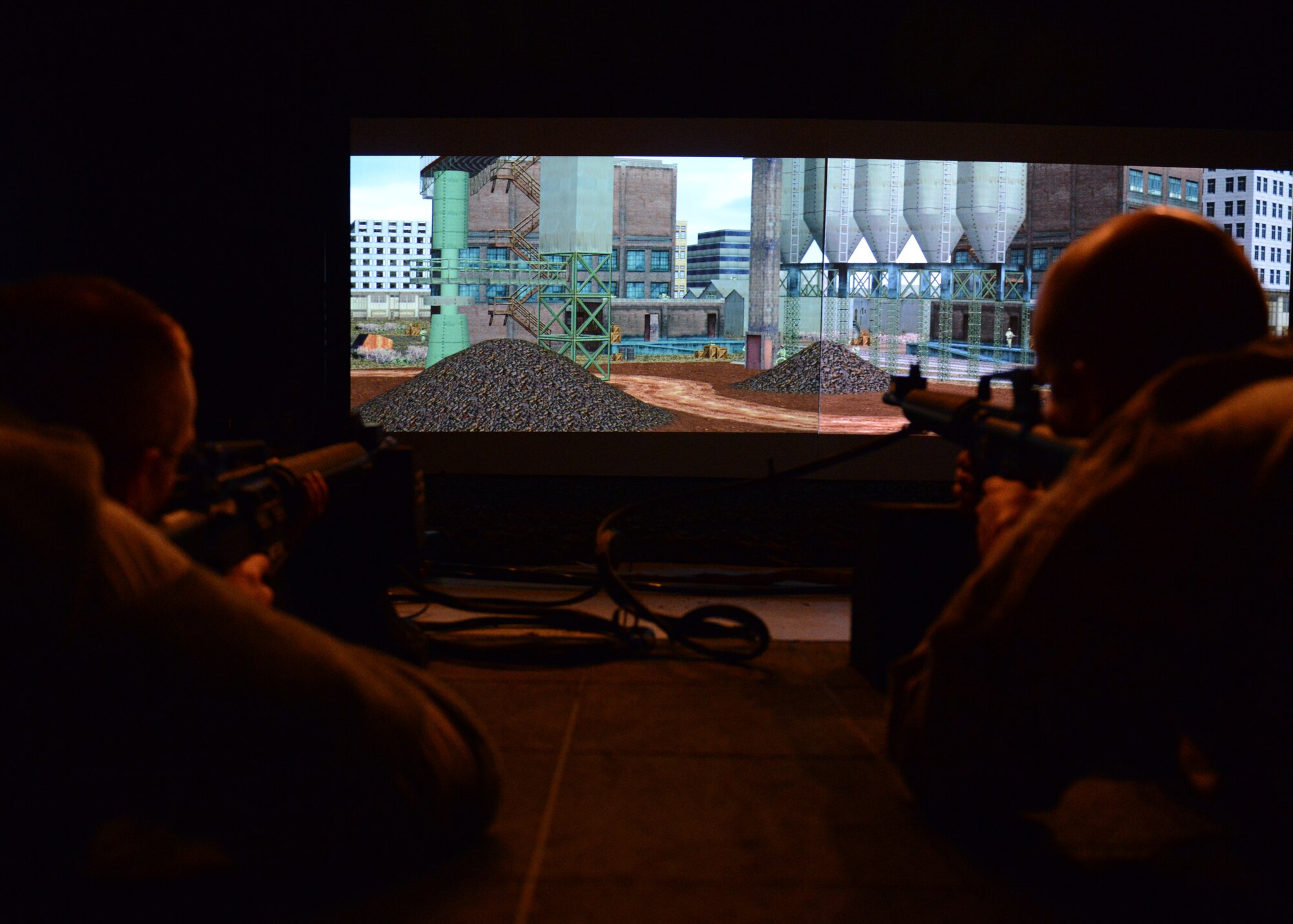 U.S. Airmen shoot simulated targets on an engagement skills trainer at the Combat Arms Training and Maintenance facility Feb. 12, 2015, Eielson Air Force Base, Alaska. Airmen attended an M4 requalification course.  (U.S. Air Force photo by Senior Airman Ashley Taylor/Released)
