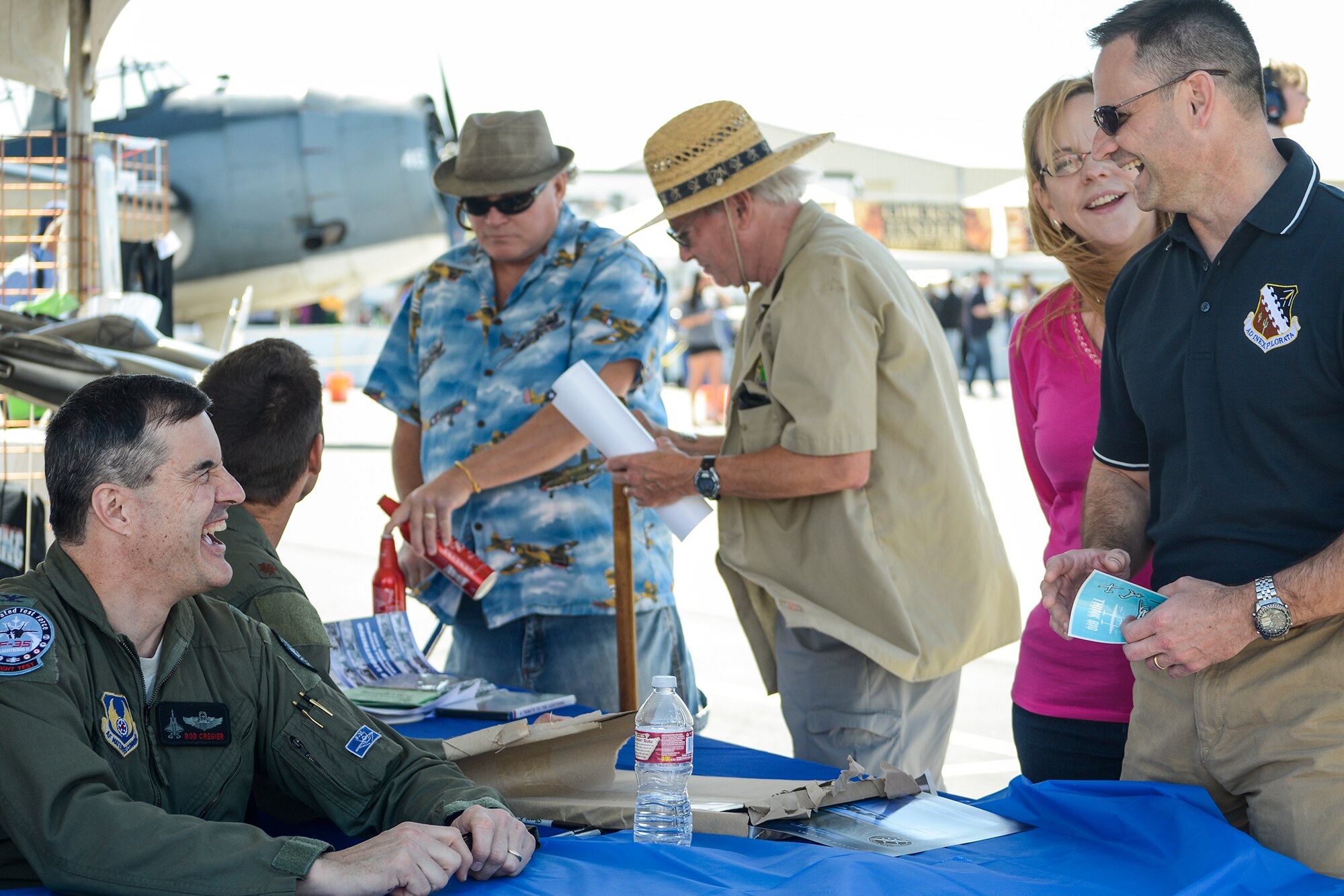 Air Force Col. Roderick Cregier (left), F-35 director at Edwards AFB, joined Maj. Logan Lamping, 416th Flight Test Squadron and F-35 test pilot, to sign lithographs of the P-38 and F-35 at the P-38 National Association booth at the 2015 L.A. County Air Show March 21. (U.S. Air Force photo by Rebecca Amber)