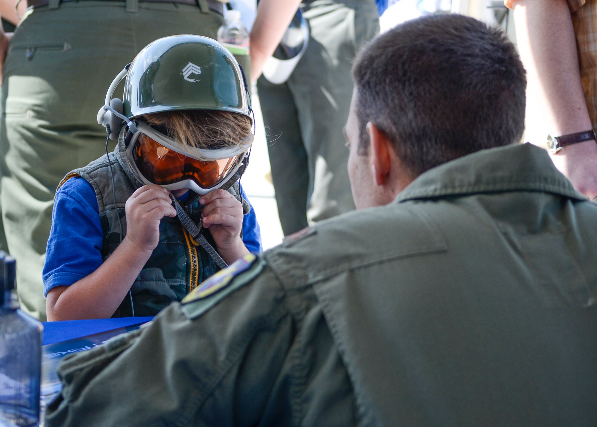 Maj. Logan Lamping, 416th Flight Test Squadron and F-35 test pilot, signs a lithograph of the P-38 and F-35 for a young child at the L.A. County Air Show. (U.S. Air Force photo by Rebecca Amber)