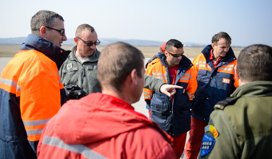 Master Sgt. Steven Bevier, 52nd Civil Engineer Squadron fire chief, discusses fire fighting methods used by U.S. Airmen with Romanian firefighters at Campia Turzii, March 23, 2015. Air advisors from the 435th Air Ground Operations Wing set up events to increase interoperability between the U.S. and Romanian air forces during the Dacian Warhawk mission. (U.S. Air Force photo/Staff Sgt. Armando A. Schwier-Morales)
