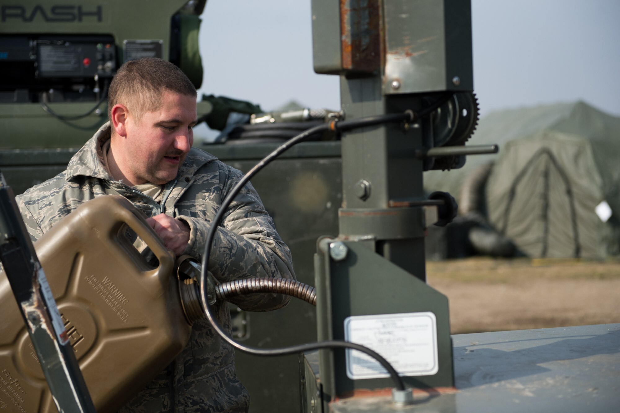 Staff Sgt. Charles Heady, 435th Air Mobility Squadron contingency aerospace ground equipment technician, refuels a light at Campia Turzii, Romania, March 22, 2015. As part of the 435th Air Ground Operations Wing, Heady and other Airmen helped established and maintained a bare base for operations during Dacian Warhawk, a two-week training mission designed to increase the interoperability between U.S. and Romanian air forces. (U.S. Air Force photo/Staff Sgt. Armando A. Schwier-Morales)
