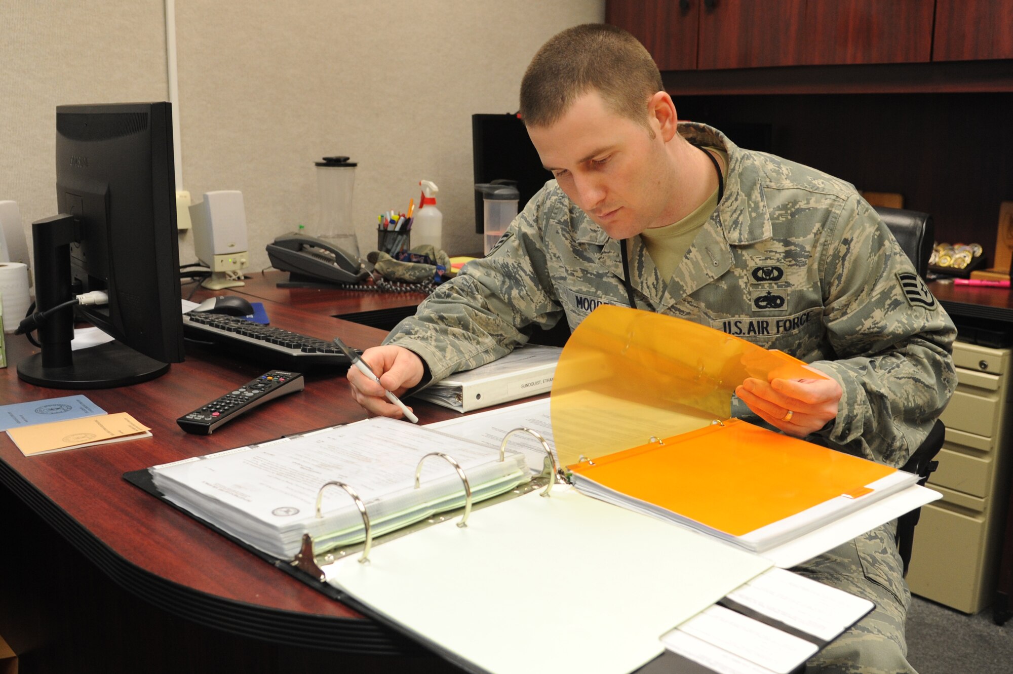 Staff Sgt. Andy Moore, 319th Air Base Wing Command Post NCO-in-charge of C2 systems, goes over training records in th CP Training office on Grand Forks Air Force Base, N.D., March 24, 2015. Moore was selected as the Warrior of the Week for the fourth week of March 2015. (U.S. Air Force photo by Staff Sgt. David Dobrydney/Released)