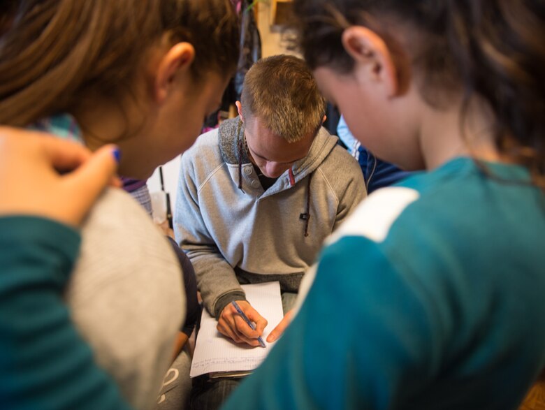 Senior Airman David Vogt, 1st Combat Communications Squadron radio frequency transmission technician, teaches English to children at a local community center at Campia Turzii, Romania, March 20, 2015. The Airmen visited the center for less-than-fortunate children from the local area to bring gifts, teach English and play games with more than 50 children attending an after school education program. (U.S. Air Force photo/Staff Sgt. Armando A. Schwier-Morales)