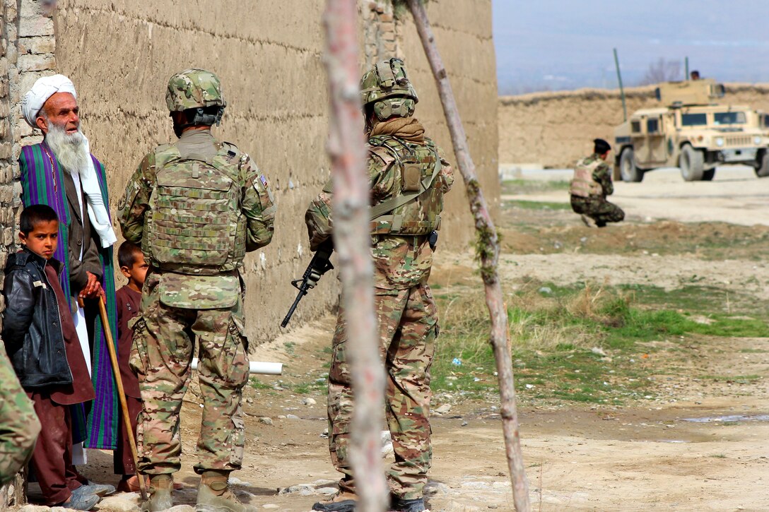 U.S soldiers talk to a local villager during a patrol outside of the Qaleh Musa Pain village in Helmand province, Afghanistan, March 12, 2015.