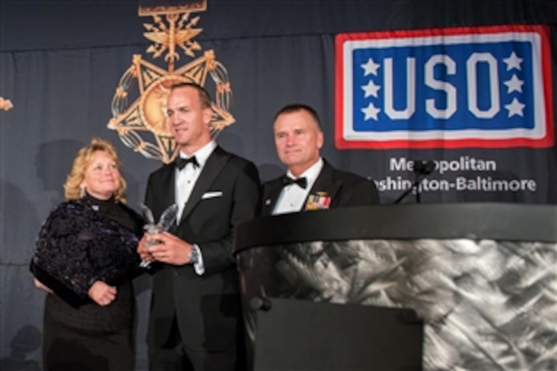 Navy Adm. James A. Winnefeld Jr., right, vice chairman of the Joint Chiefs of Staff, and his wife, Mary, present a USO-Metro Merit Award to Denver Broncos quarterback Peyton Manning during the USO of Metropolitan Washington-Baltimore's 33rd awards dinner in Arlington, Va., March 24, 2015. Manning received the award for supporting the military through USO tours and visits with wounded, ill and injured service members.