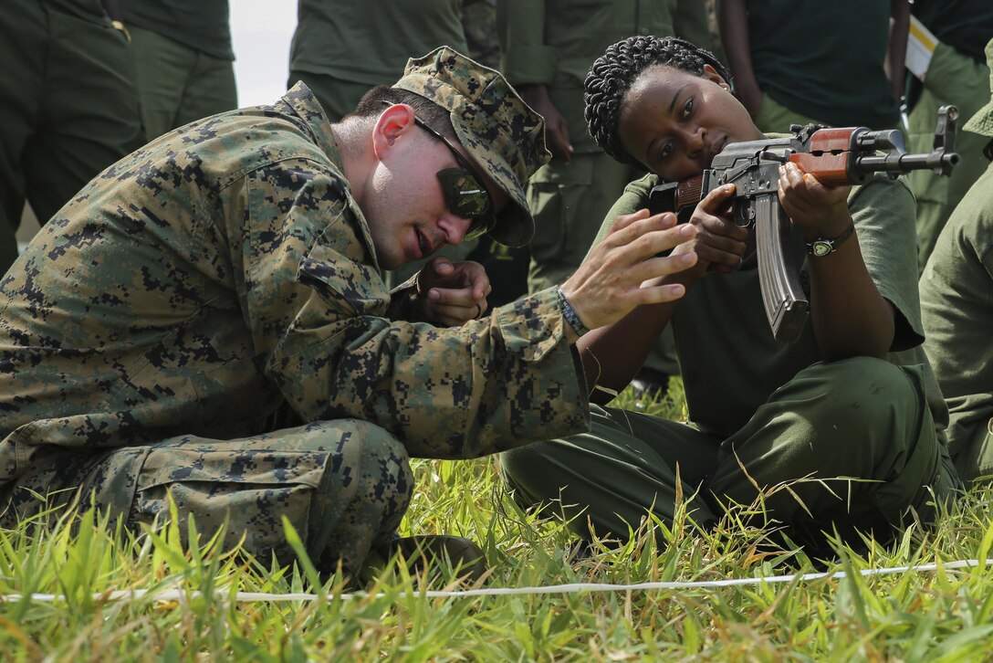 U.S. Marine Cpl. Joseph Kakascik, left, a rifleman and team leader assigned to the Theater Security Cooperation team with Special-Purpose Marine Air-Ground Task Force Crisis Response-Africa, shows a Tanzanian park ranger how to aim an AKM rifle from the sitting position at the Selous Game Reserve in Matambwe, Tanzania, March 3, 2015. The Marines and Sailors with the team will spend the next several weeks teaching the Tanzanian park rangers infantry skills such as patrolling, offensive tactics, land navigation and mounted operations to aid in counter illicit-trafficking efforts. (U.S. Marine Corps photo by Lance Cpl. Lucas J. Hopkins/Released)