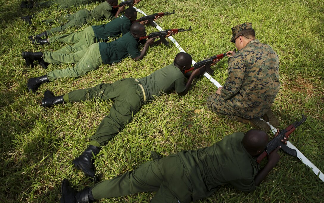 U.S. Marine Sgt. Kyle Kimbriel, right, the noncommissioned officer in charge of the Theater Security Cooperation team with Special-Purpose Marine Air-Ground Task Force Crisis Response-Africa, helps a Tanzanian park ranger aim an AKM assault rifle in the prone position during a combat marksmanship class at the Selous Game Reserve in Matambwe, Tanzania, March 3, 2015. The Marines and Sailors will spend the next several weeks teaching the Tanzanian park rangers infantry skills such as patrolling, offensive tactics, land navigation and mounted operations to aid in countering illicit trafficking. (U.S. Marine Corps photo by Lance Cpl. Lucas J. Hopkins/Released)