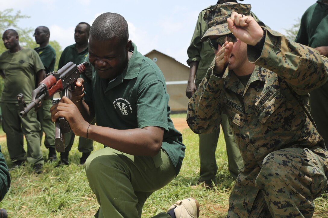 U.S. Marine Cpl. Joseph Kakascik, right, a rifleman and team leader assigned to Theater Security Cooperation team with Special-Purpose Marine Air-Ground Task Force Crisis Response-Africa, guides a Tanzanian park ranger through reload drills during a combat marksmanship class aboard the Selous Game Reserve in Matambwe, Tanzania, March 3, 2015. Kakascik was part of a team of Marines and Sailors who taught the park rangers proper weapons handling and combat marksmanship techniques. (U.S. Marine Corps photo by Lance Cpl. Lucas J. Hopkins/Released)