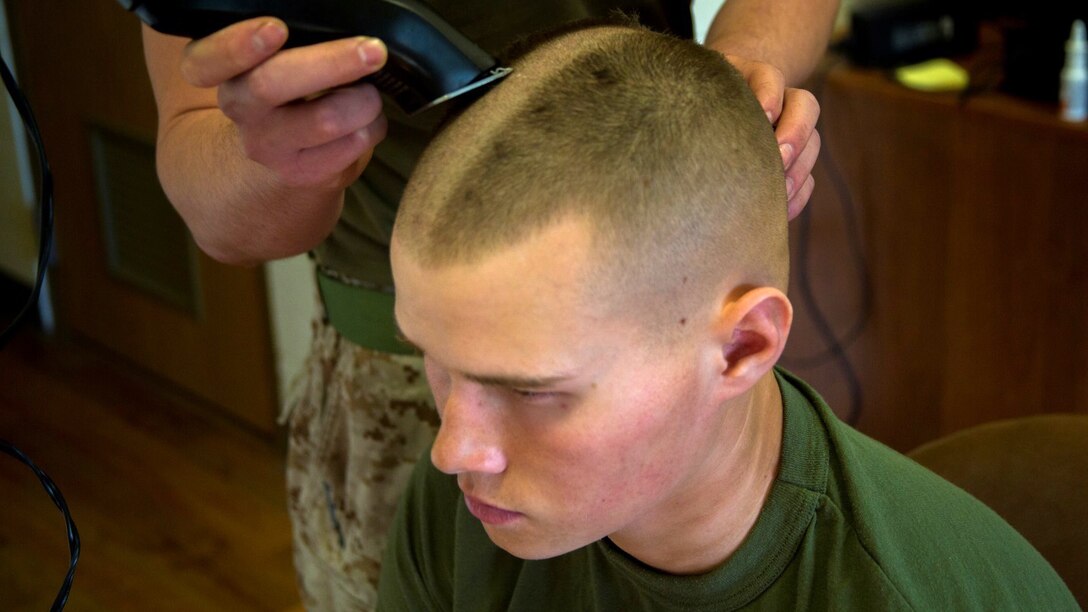 Pfc. Corey Kush, a rifleman with 1st Platoon, Kilo Company, 3rd Battalion, 8th Marine Regiment, receives a haircut in the barracks aboard Marine Corps Base Camp Lejeune, N.C., March 24, 2015. Marines with the platoon volunteered for their heads to be shaved in support of the platoon sergeant's daughter, Katie Whatley, who is fighting cancer.