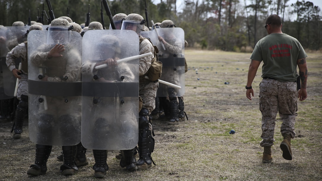 Staff Sgt. Shawn J. Dyer, the lead non-lethal weapons instructor with Expeditionary Operations Training Group, II Marine Expeditionary Force, observes the Marines of Battery and Golf Co., 2nd Battalion, 6th Marines, as they perform various riot control techniques during non-lethal weapons training aboard Camp Lejeune, N.C., March 24, 2015. “The Marines here are doing really well,” Dyer said. “At first, it’s difficult for an infantry unit to come here and get used to moving in close formations with the shields, but they’re learning quickly.”