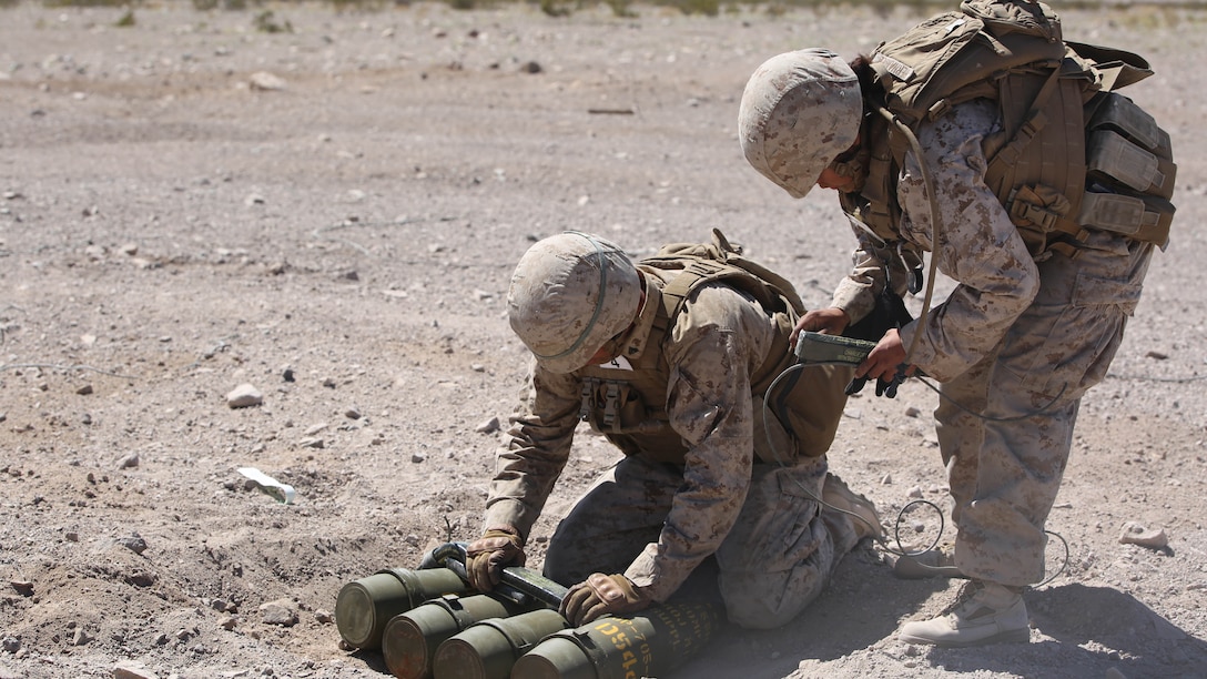 Cpl. Joshua J. Syverson, left, and Cpl. Alicia Hernandez, right, both combat engineers with Engineer Platoon, Headquarters and Service Company, Ground Combat Element Integrated Task Force, prepare C4 charges and detonation cord for cache reduction during a Marine Corps Operational Test and Evaluation Activity assessment at Range 107, Marine Corps Air Ground Combat Center Twentynine Palms, California, March 22, 2015. From October 2014 to July 2015, the GCEITF will conduct individual and collective level skills training in designated ground combat arms occupational specialties in order to facilitate the standards-based assessment of the physical performance of Marines in a simulated operating environment performing specific ground combat arms tasks. 