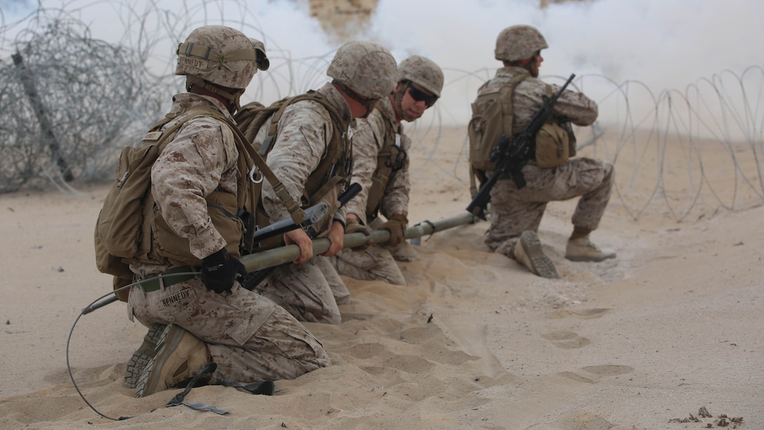 Marines with Engineer Platoon, Headquarters and Service Company, Ground Combat Element Integrated Task Force, snap M1A2 Bangalores together under the concealment of smoke for a hasty breach during a Marine Corps Operational Test and Evaluation Activity assessment at Range 107, Marine Corps Air Ground Combat Center Twentynine Palms, California, March 22, 2015. From October 2014 to July 2015, the GCEITF will conduct individual and collective level skills training in designated ground combat arms occupational specialties in order to facilitate the standards-based assessment of the physical performance of Marines in a simulated operating environment performing specific ground combat arms tasks. 