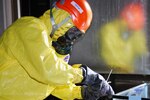 A member of the Alaska National Guard 103rd Civil Support Team collects a sample during a training exercise. The 103rd Civil Support Team mission is to assess hazards, advise civil authorities, and facilitate military support during emergencies and incidents of suspected weapons of mass destruction.
