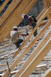 Soldiers of the 1021st Engineer Company, 205th Engineer Battalion prepare braces for the school walls, that will be filled with concrete in order to construct a roof for the Diaquoi School Project in Haiti on July 12, 2010.