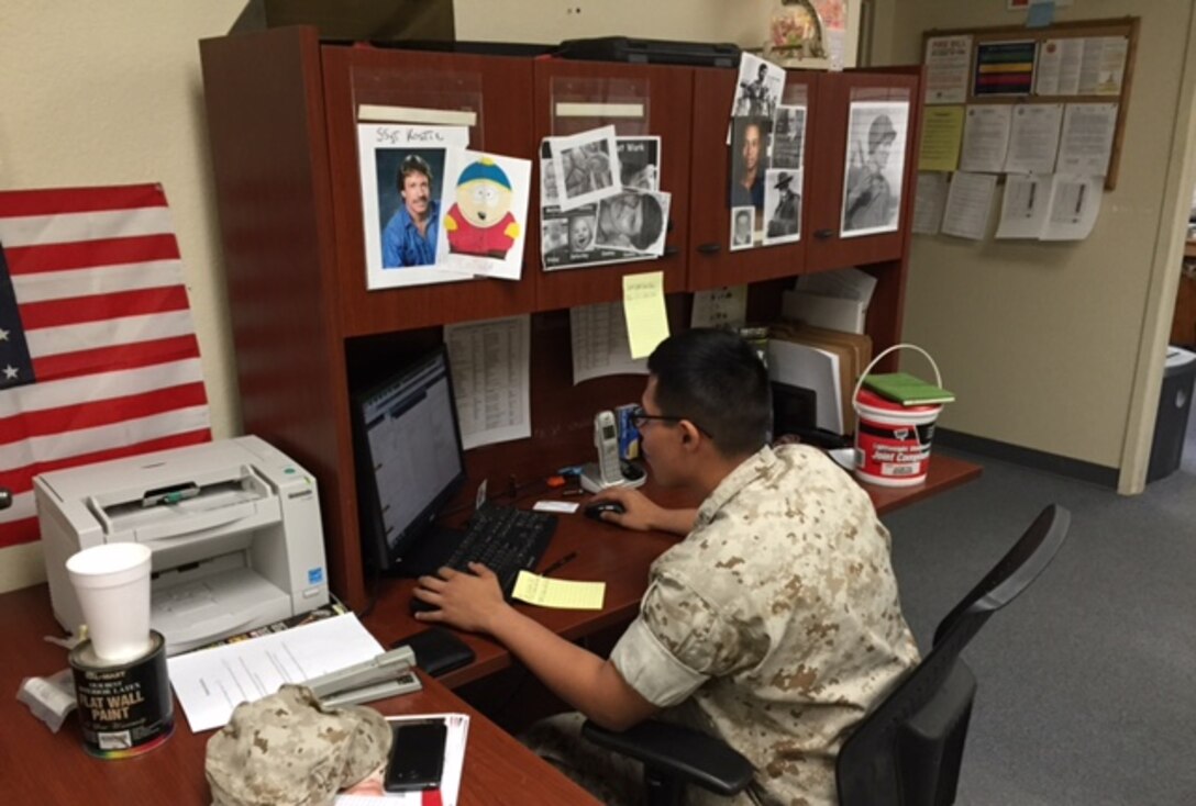 LCpl James W. Holiday II, an administrative awards specialist, works on an endorsement as well as awards for Marines in HqCo, MCCES.