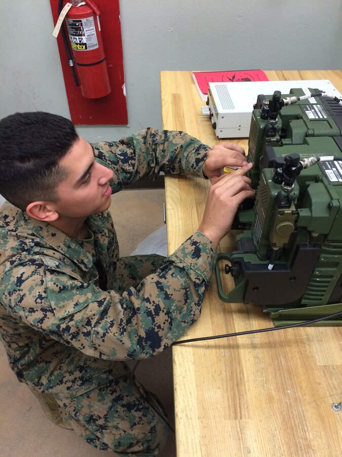LCpl Victor M. Puente is programing a RT-1916 in the VRC-110 system to establish communications.