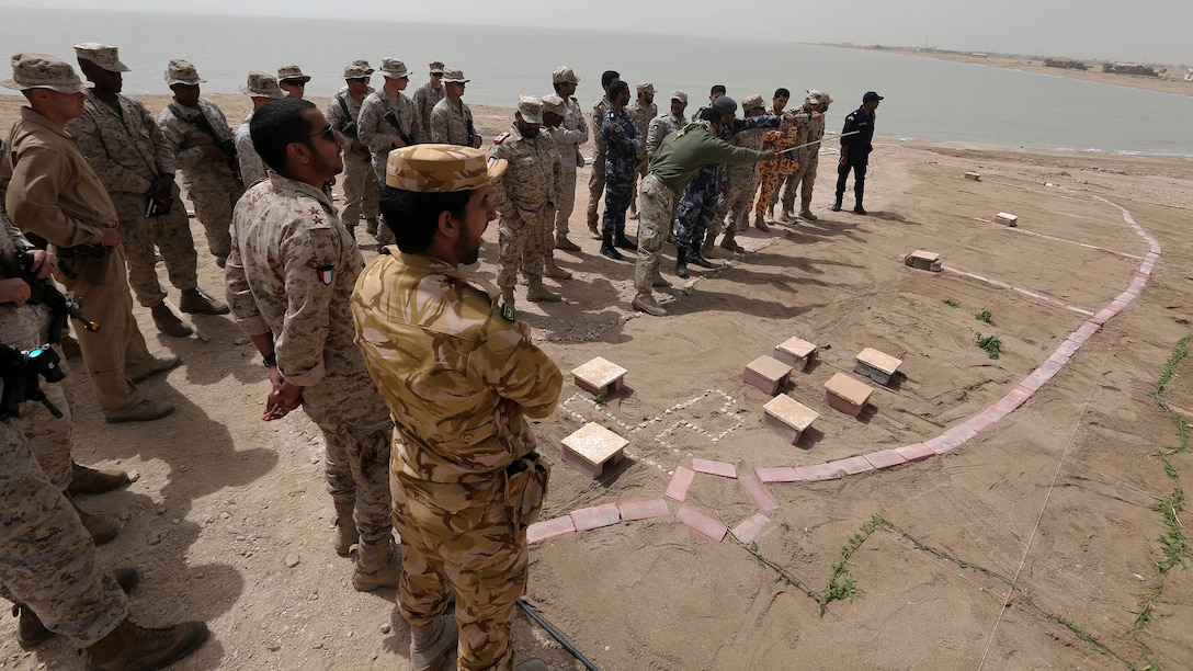 U.S. Marines with Kilo Company, Battalion Landing Team 3rd Battalion, 6th Marine Regiment, 24th Marine Expeditionary Unit, and service members from Kuwait, Qatar, Turkey and Saudi Arabia use a terrain model to discuss plans for an amphibious landing during Exercise Eagle Resolve 2015 at Failaka Island, Kuwait, March 23, 2015. Eagle Resolve is the premiere Arabian Peninsula/gulf region exercise among the United States, Gulf Cooperation Council nations, and international partners. It serves to address regional challenges associated with asymmetric/unconventional warfare in a multi-national environment. 