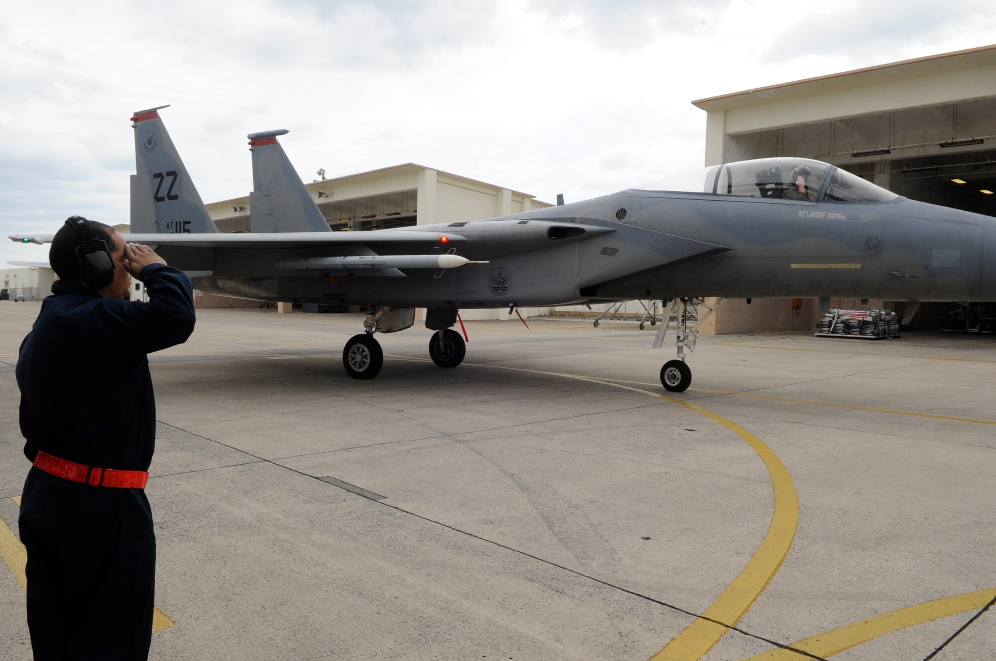 U.S. Air Force Airman 1st Class Michael Santiago, 67th Aircraft Maintenance Unit dedicated crew chief, salutes Maj. Johnny Koegel, 67th Fighter Squadron pilot, after completing a preflight check during a sortie surge on Kadena Air Base, Japan, March 25, 2015. The 67th FS broke a Kadena record on March 26, 2015, by flying 278 sorties in four days. A sortie is a mission from the moment an aircraft takes off to when it lands. (U.S. Air Force photo by Staff Sgt. Marcus Morris)