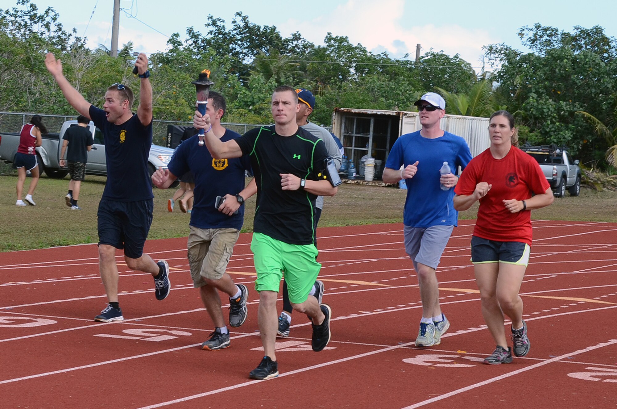 Staff Sgt. Eric Mattson, 554th RED HORSE Squadron, carries the Special Olympics Flame of Hope Torch at Okkodo High School in Dededo, Guam, March 21, 2015. More than 300 service members from all military branches assigned to units on Guam came together to support Special Olympic athletes in a variety of track and field events. (U.S. Air Force photo by Airman 1st Class Alexa Ann Henderson/Released)
